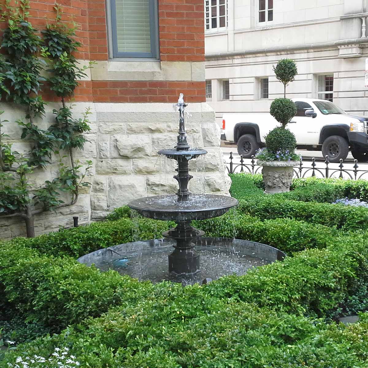 Lead Fountain in Boxwood Parterre in front of building with plants surrounding